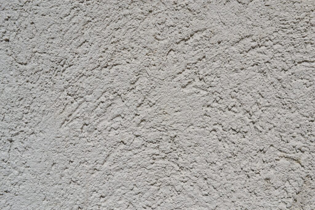 Close-up of a light gray stucco wall texture, ideal for backgrounds.